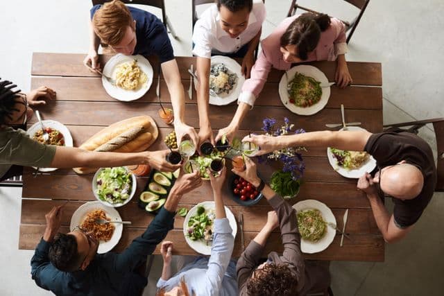 Overhead view of friends sharing a long dinner table